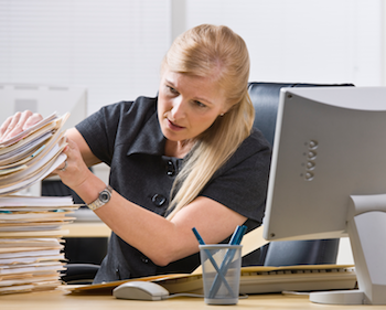 woman in office looking through a pile of files